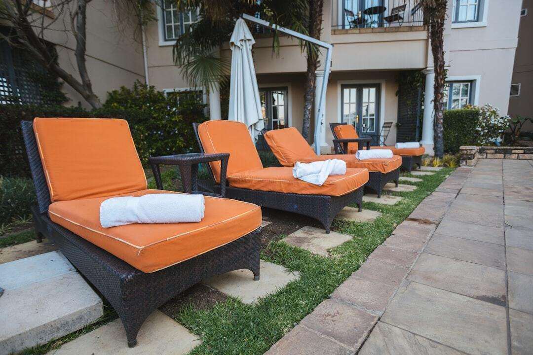 Contemporary outdoor lounge chairs arranged beside a swimming pool