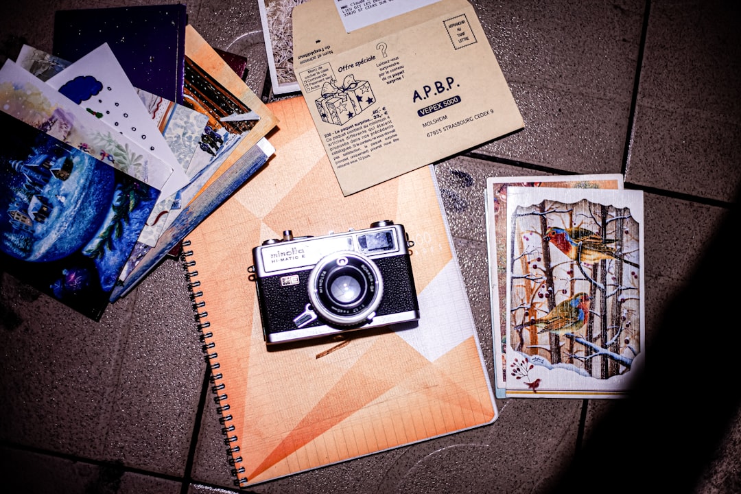Assortment of photo album materials including adhesive tape, corner mounts, and archival paper on white surface