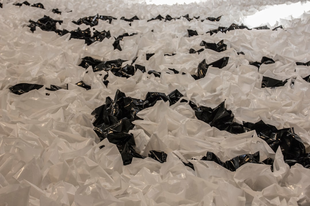 Hand holding iron over brown paper bag on carpet to remove wax stain